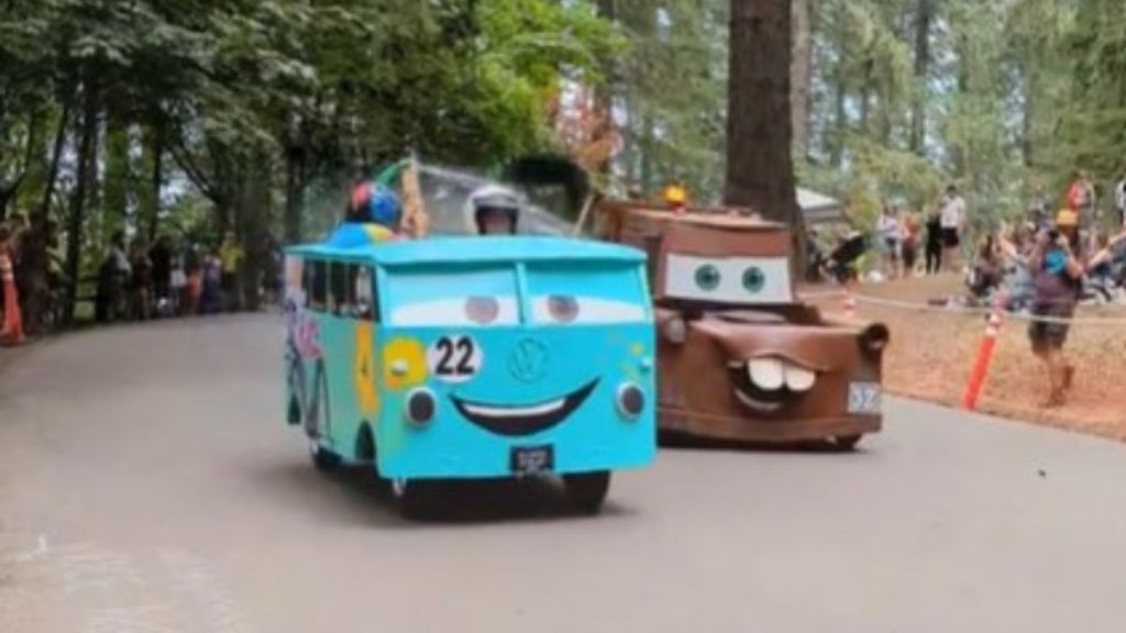 Image shows a "peace van" and Mater the Tow Truck almost tied during the Portland Adult Soap Box Derby.