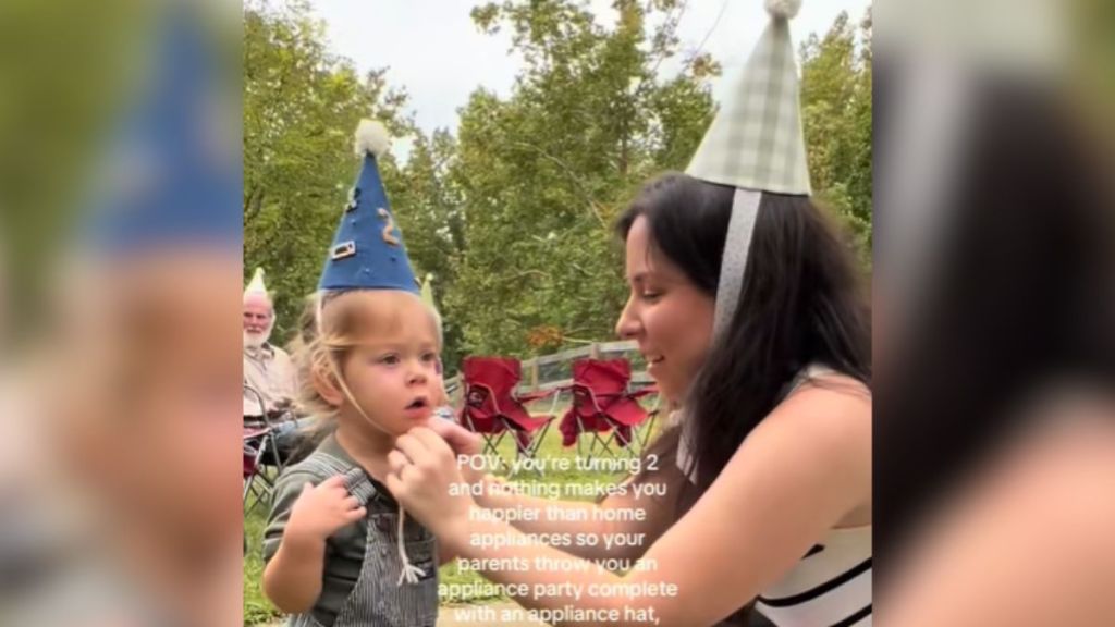 A mom and child wearing birthday party hats.