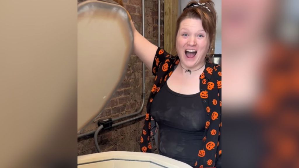 A woman looks excited as she opens a large container.