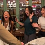 Tara Davis-Woodhall happily screams with two fans. All three of them have them mouths open wide as they react to something exciting