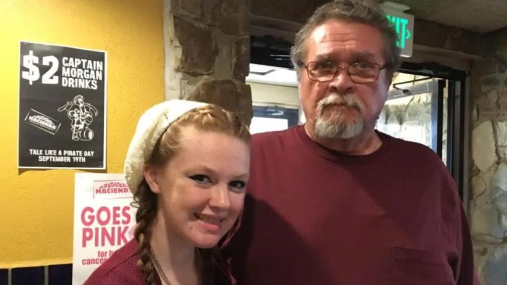 A young woman smiling next to her stepdad.