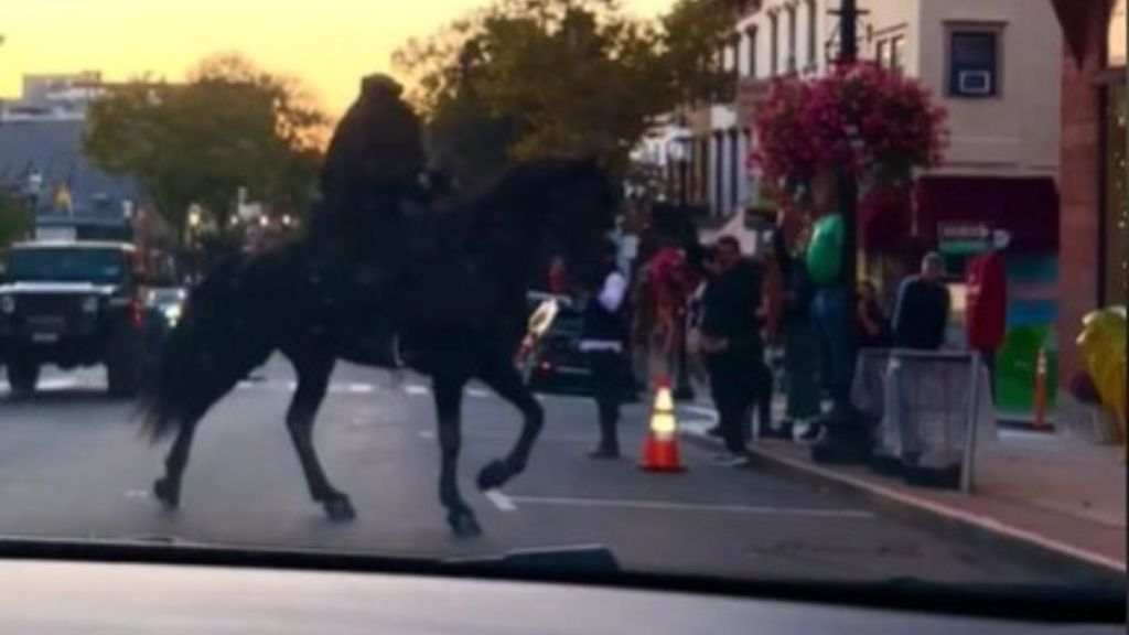 Image shows a headless horseman riding through the streets of Sleepy Hollow, New York.