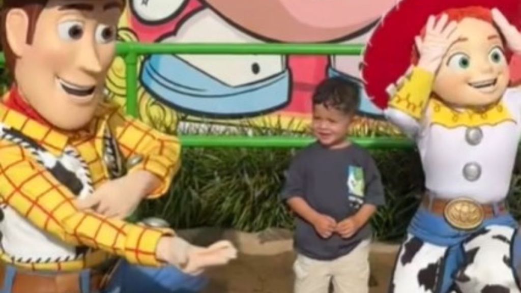 Image shows Woody pointing at his right arm as Jesse looks surprised and a young boy interacts with the characters.