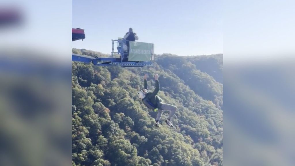 A base jumper in mid-air over a beautiful location.