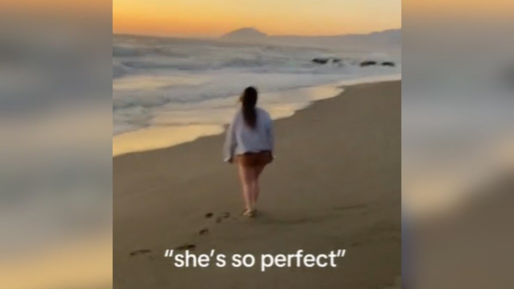 View from a distance of a woman walking down the beach and away from the person capturing this moment. The sun is setting. Text on the image reads: "She's so perfect."