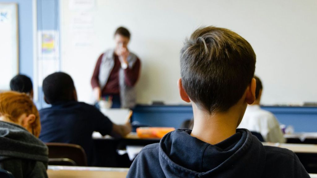 A classroom full of students looking at their teacher.