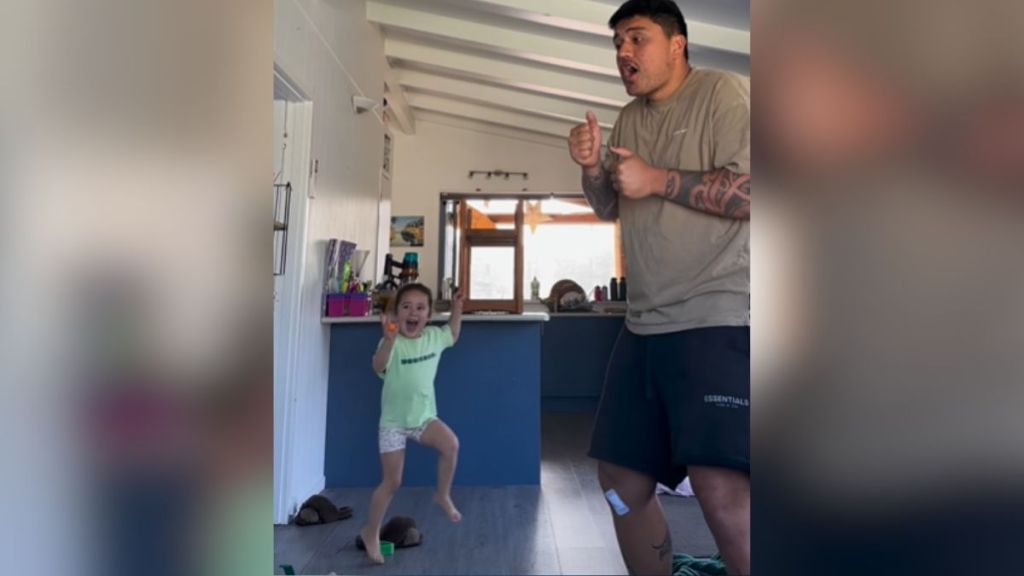 A dad dancing with his small daughter.