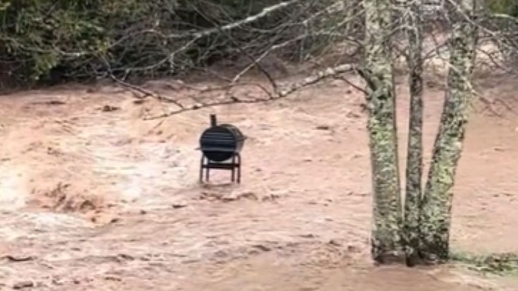 A grill standing in the middle of a flash flood.