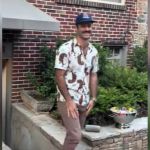 A man walking outside in a baseball cap.