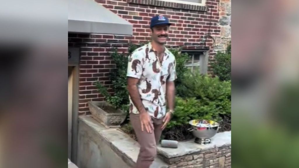 A man walking outside in a baseball cap.