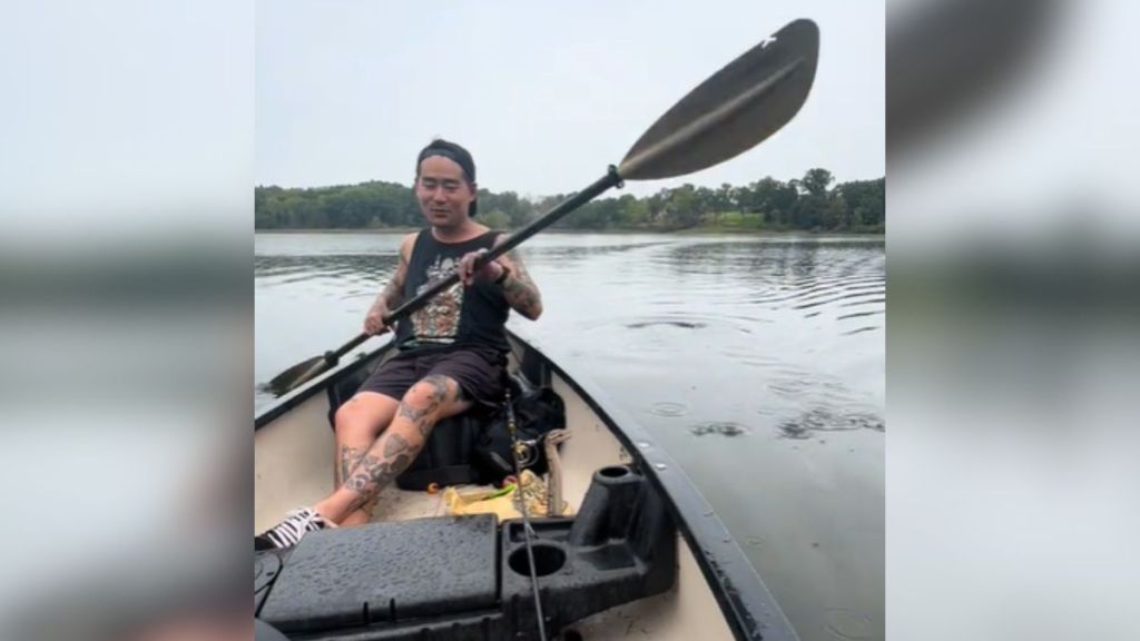 A man sitting in a boat with a snake.