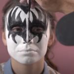 Image shows Gene Simmons applying his stage makeup on his daughter.