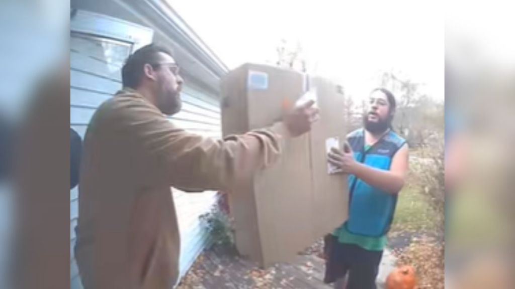 An Amazon driver handing a man his package.