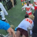 A little kid falls forward, between guardrails, at a football stadium. Chiefs player Tershawn Wharton starts to reach out, eyes wide