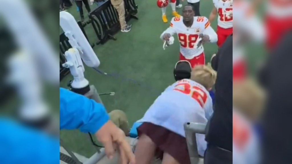 A little kid falls forward, between guardrails, at a football stadium. Chiefs player Tershawn Wharton starts to reach out, eyes wide