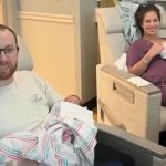 A man holding two babies next to a smiling woman holding one baby.