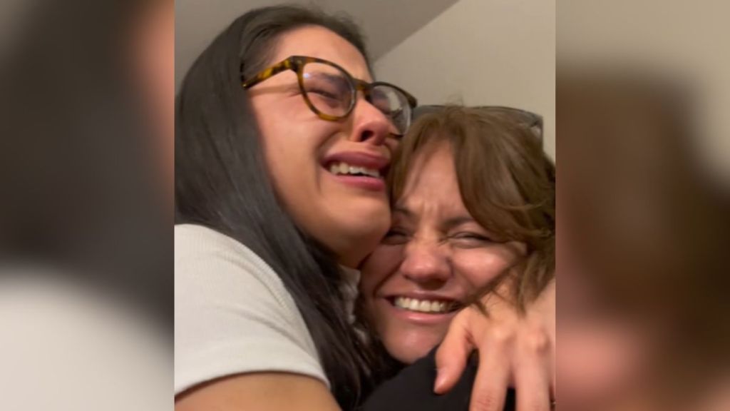 A young woman crying and hugging her mom.