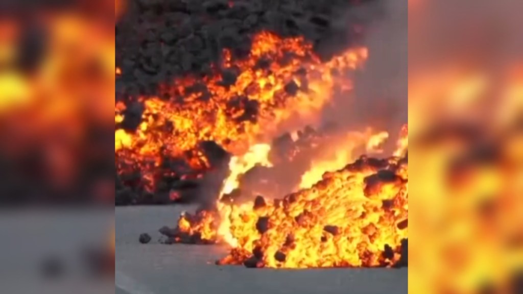 View of lava pouring out onto a parking lot in Iceland