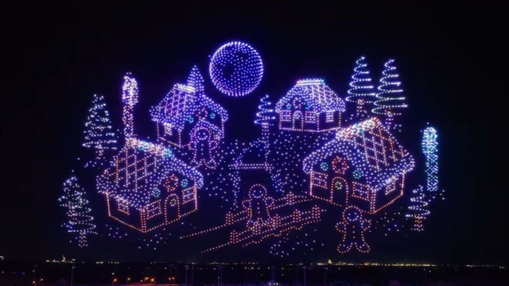 Image shows a gingerbread village displayed in the sky using drones.