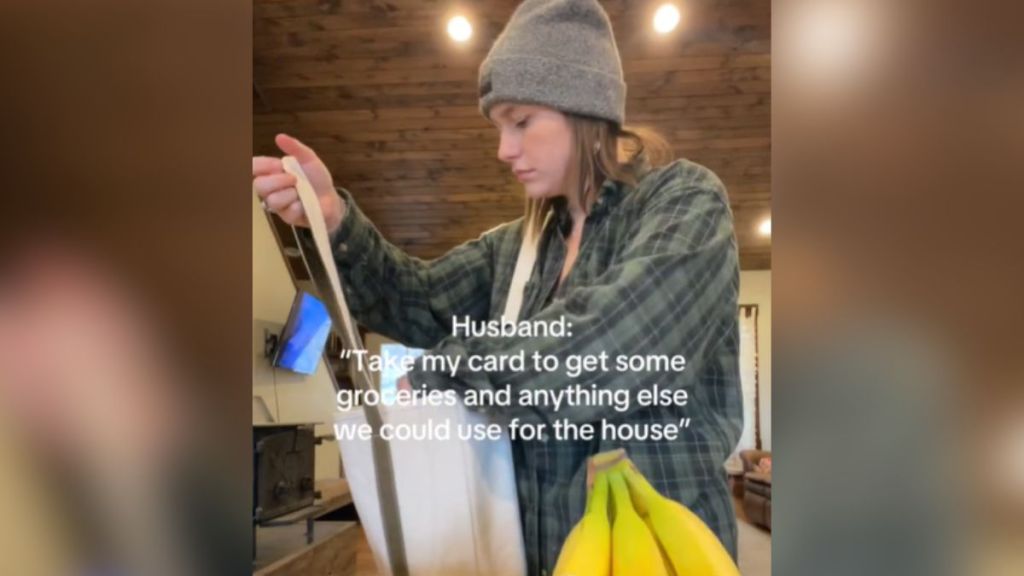 A woman reaching into a grocery bag.