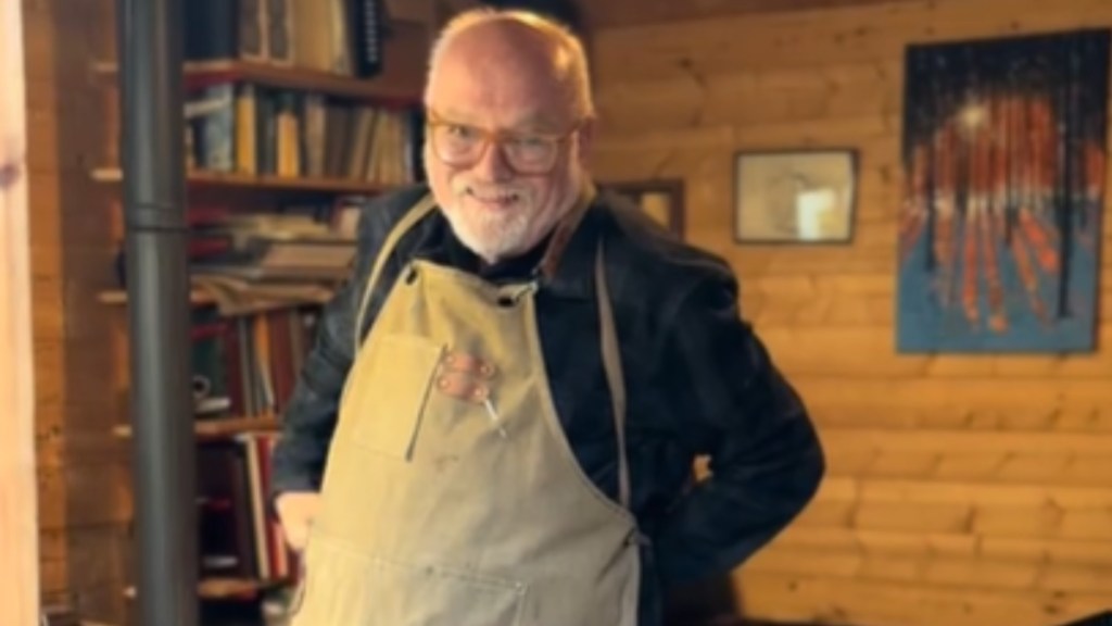 Close up of an older man smiling as he ties on his apron.