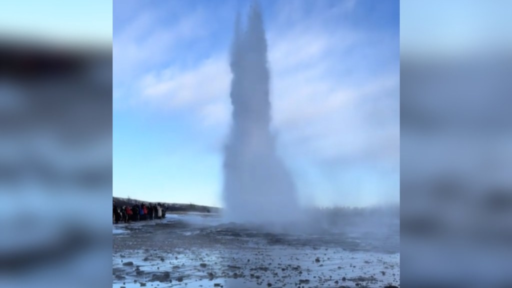 View from a distance of a frozen geyser erupting in Iceland