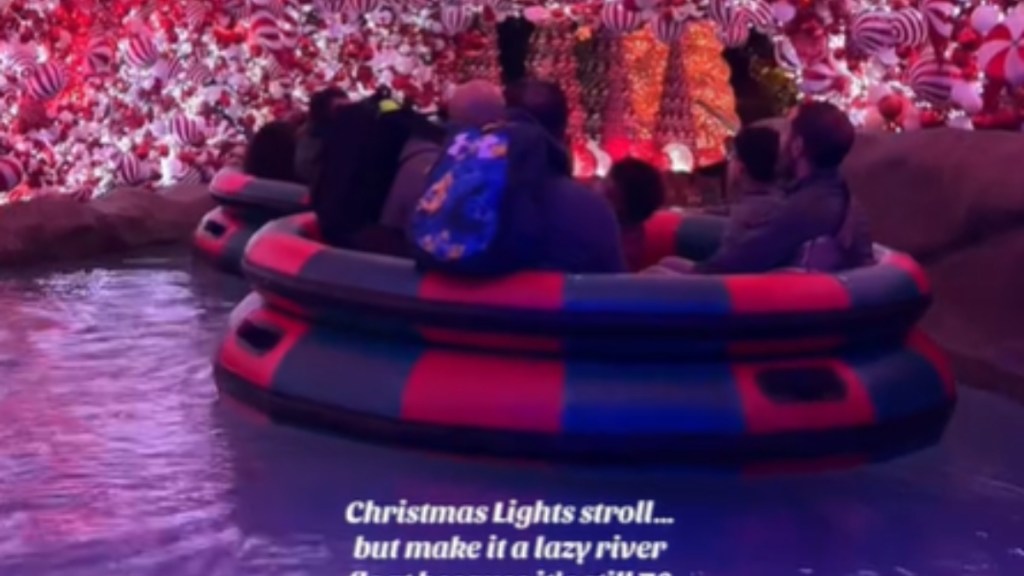 View of a group of people riding down a lazy river. Surrounding them, even from above, are Christmas lights and ornaments. Text on the image reads: Christmas lights stroll... but make it a lazy river