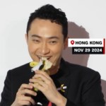 Close up of Justin Sun as he starts to take a bite of a banana from the art piece "Comedian." Text on the image reads Hong Kong. Nov. 29 2024