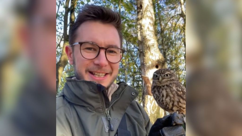 A man with an owl perched on his gloved hand.