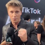 Robert Irwin looks into the camera as he talks into a mic on a red carpet. He has a hand in a fist as he talks passionately