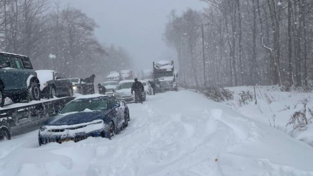 Cars and trucks stranded on the road in severe winter weather.