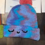 A colorful winter hat with a smiling face on it.