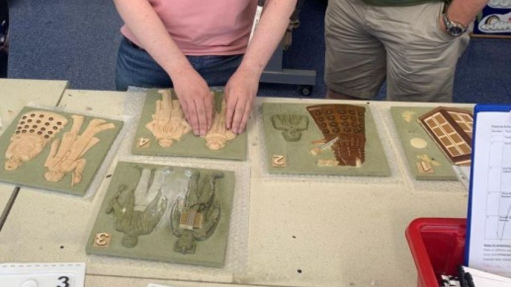 Image shows Livings Paintings book making process while a "test" reader examines a proof page.