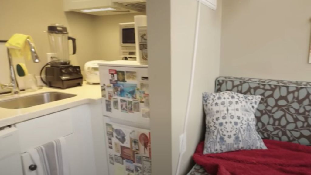 Image shows the kitchen and couch in a micro apartment at Arcade Mall.