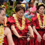 Image show Hawaiin dancers wearing yellow leis.