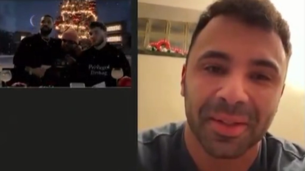 View of Drake's livestream for Drizzmas Christmas. Drake stands next to another man as they chat with the other man in the livestream, a dad named Ryan, who smiles