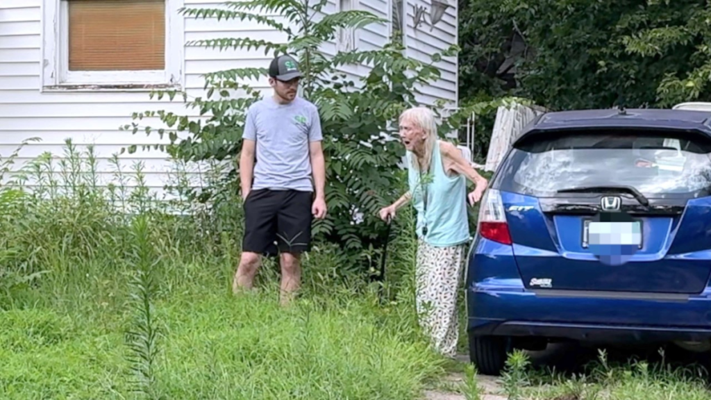 an elderly woman looking at her yard in amazement while standing next to a young man