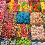 A large assortment of bright candies are stuffed into clear containers in an aesthetically pleasing way