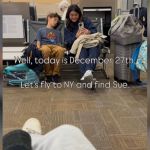 Travelers sitting in a waiting area with their bags.