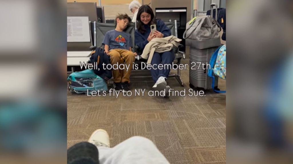 Travelers sitting in a waiting area with their bags.