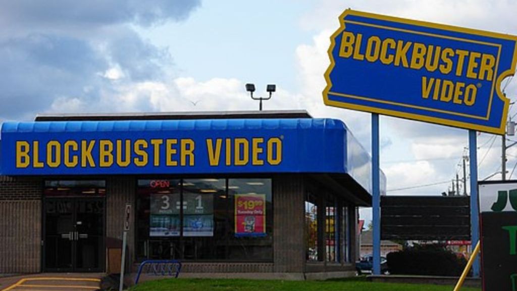 Image shows an old Blockbuster Video store with the iconic "Ticket" sign.