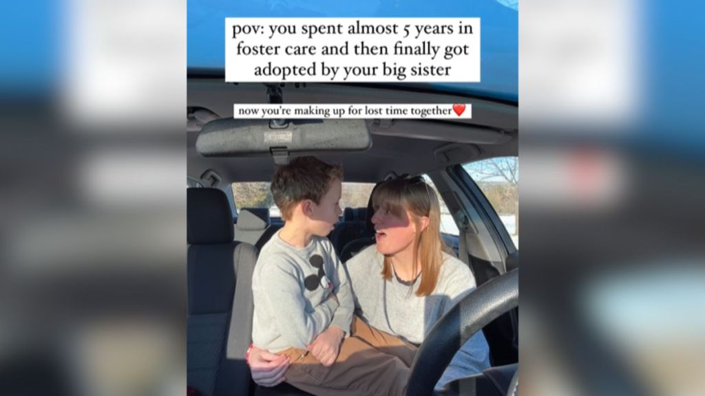 A woman sitting in the car with her little brother.