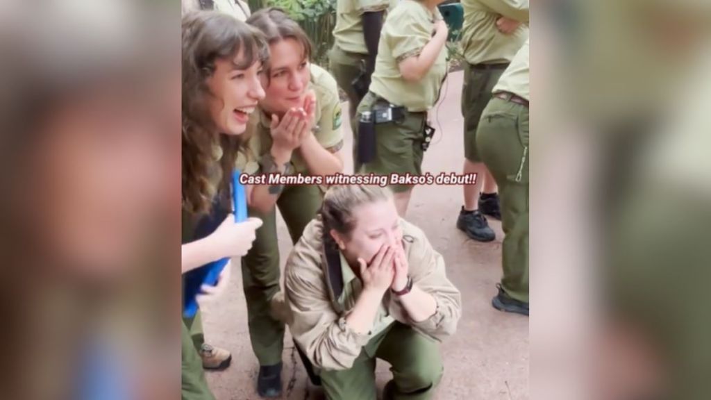 Disney World cast members with delighted expressions on their faces.