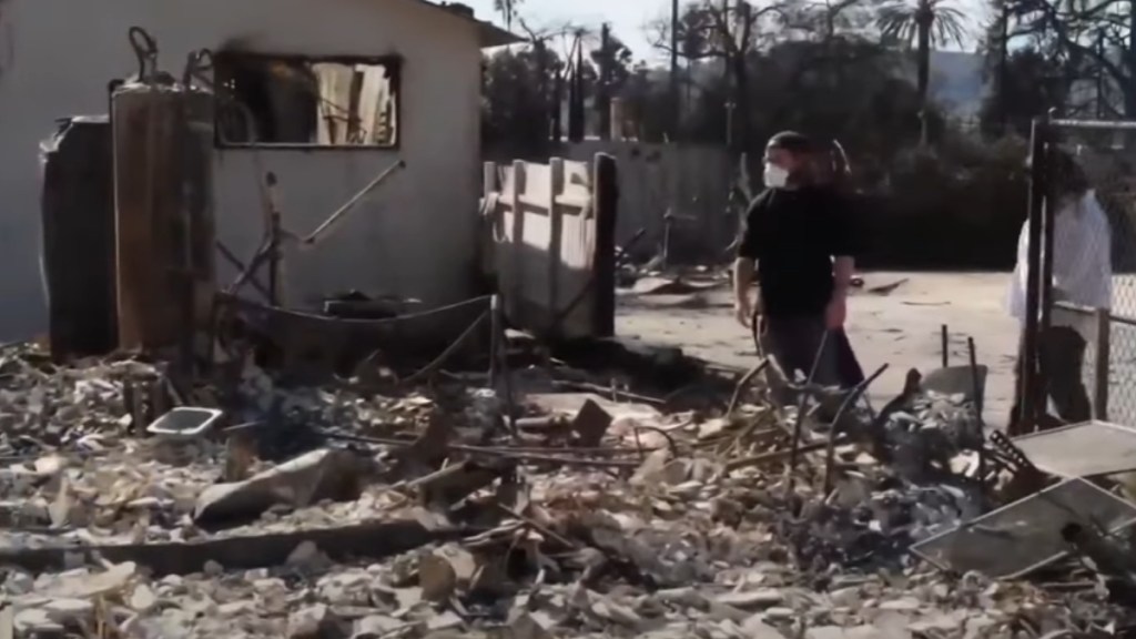 A man and woman approach their totally destroyed house from the LA fires.