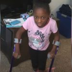 A girl with cerebral palsy walking with crutches.