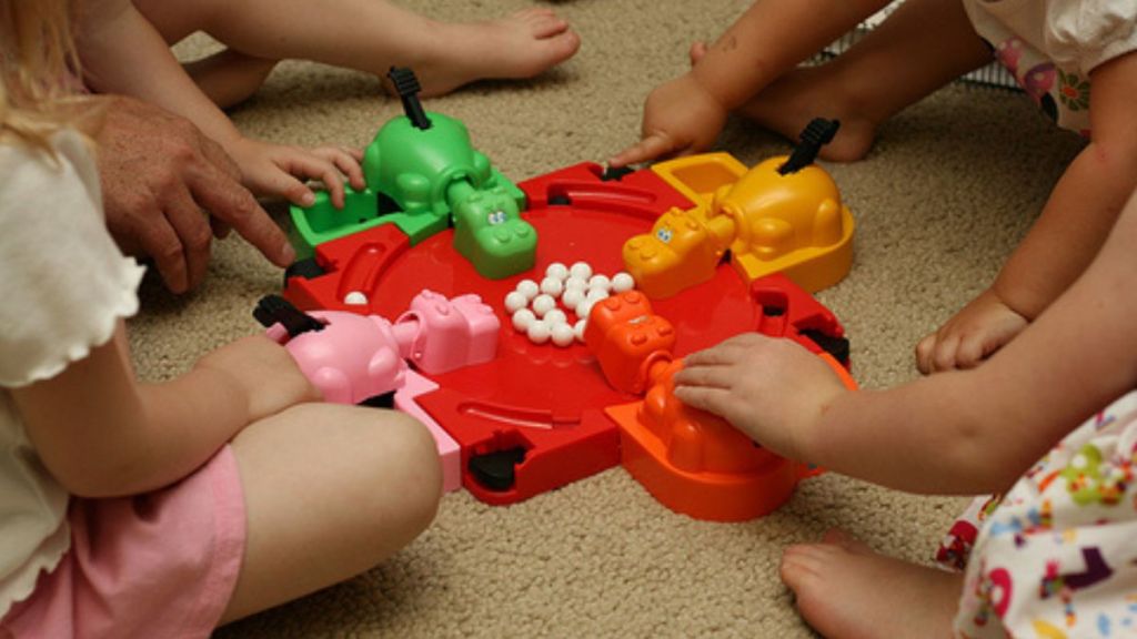 Children playing the board game "Hungry Hungry Hippos."