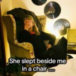 A woman sits in a chair by a bed. She has her eyes closed as she rests her head in the palm of one of her hands. Text on the image reads: She slept beside me in a chair ...