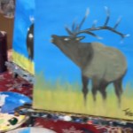 Close up of two paintings. One shows a fairly well painted moose. Peaking out from behind this painting is another one of a moose, this one much sillier looking. But it's not in full view