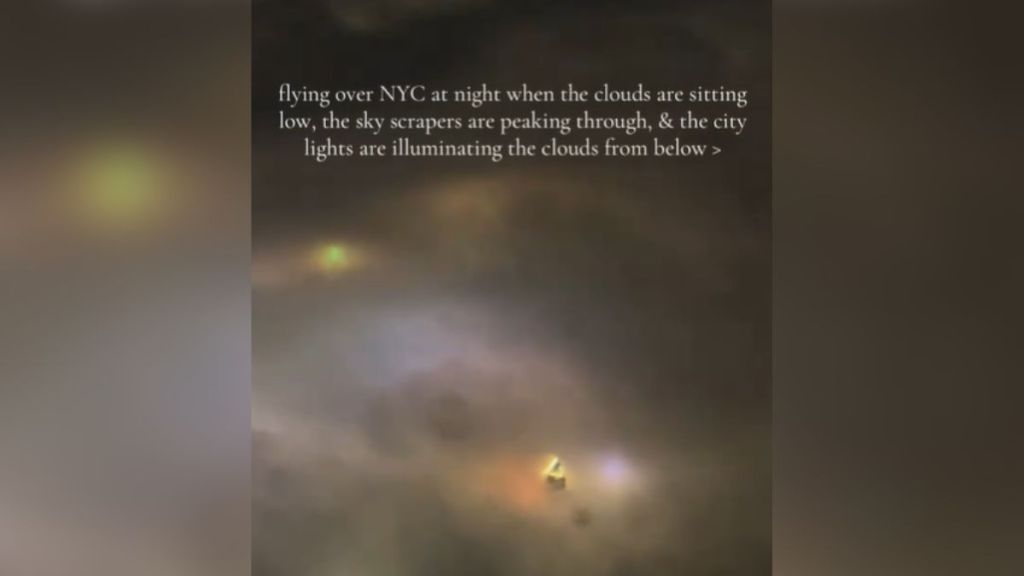 A view of a cloudy sky from an airplane window at night.