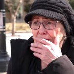 Close up of Pamela Hemphill standing outside, looking emotional. She's covering her mouth with her hand and looks on the verge of tears